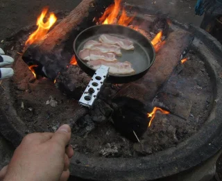 Profi-Tipp: Mit einem Stock kann man den Trangia-Griff clever verlängern, so gibt es keine verbrannten Finger mehr beim Braten über dem Feuer!