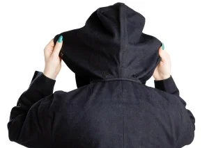 The removable hood can be buttoned under the collar. (Hood not always included, just most often.)