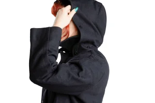 The removable hood can be buttoned under the collar. (Hood not always included, just most often.)