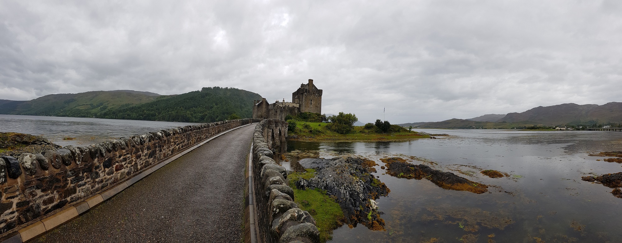A paved road in the middle of waters leading to the castle.