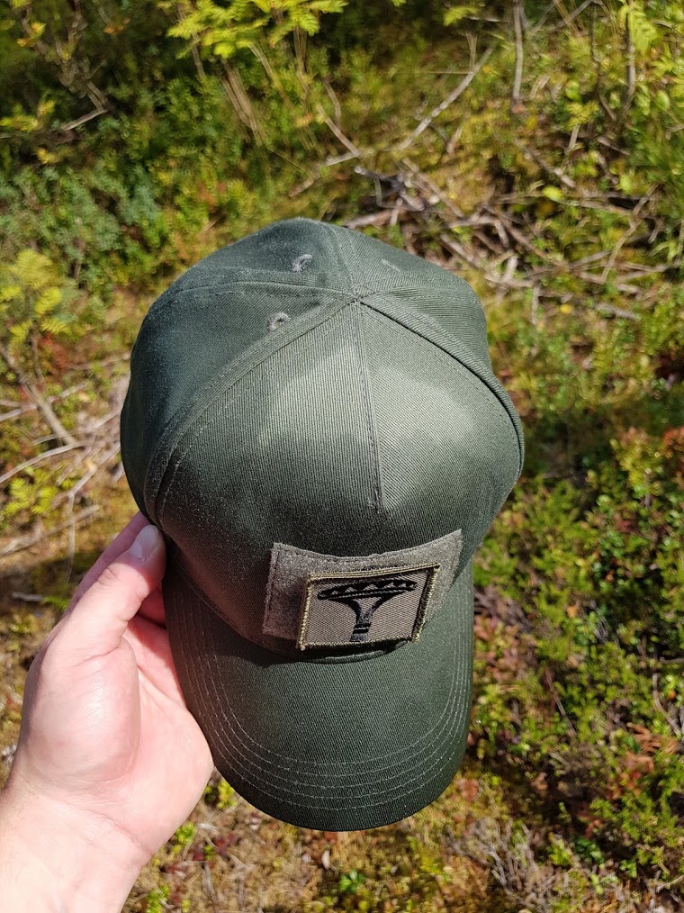 Vihreä lippis Varustelekan logolla.