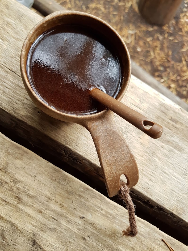 A cup of coffee in a traditional Finnish kuksa cup.