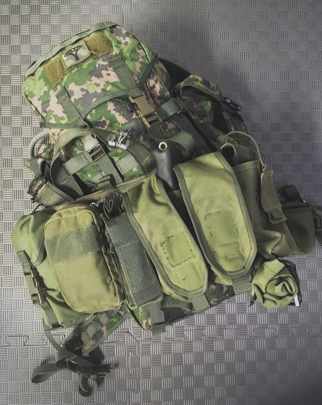 A camo backpack with a chestrig.