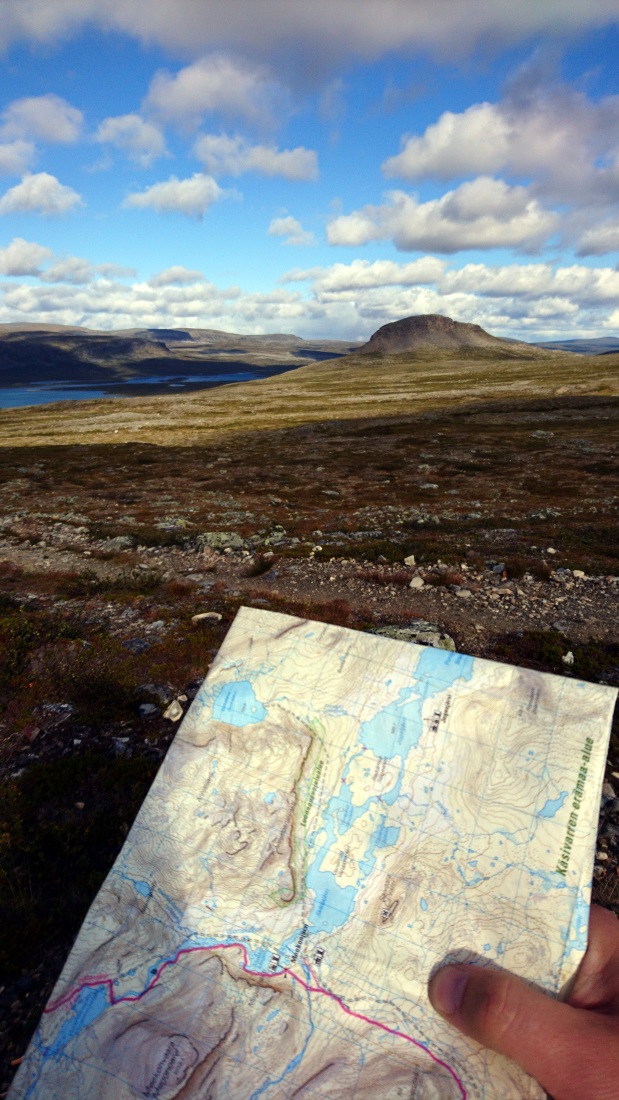 A map with a text: Käsivarren erämaa-alue with a mountain landscape.