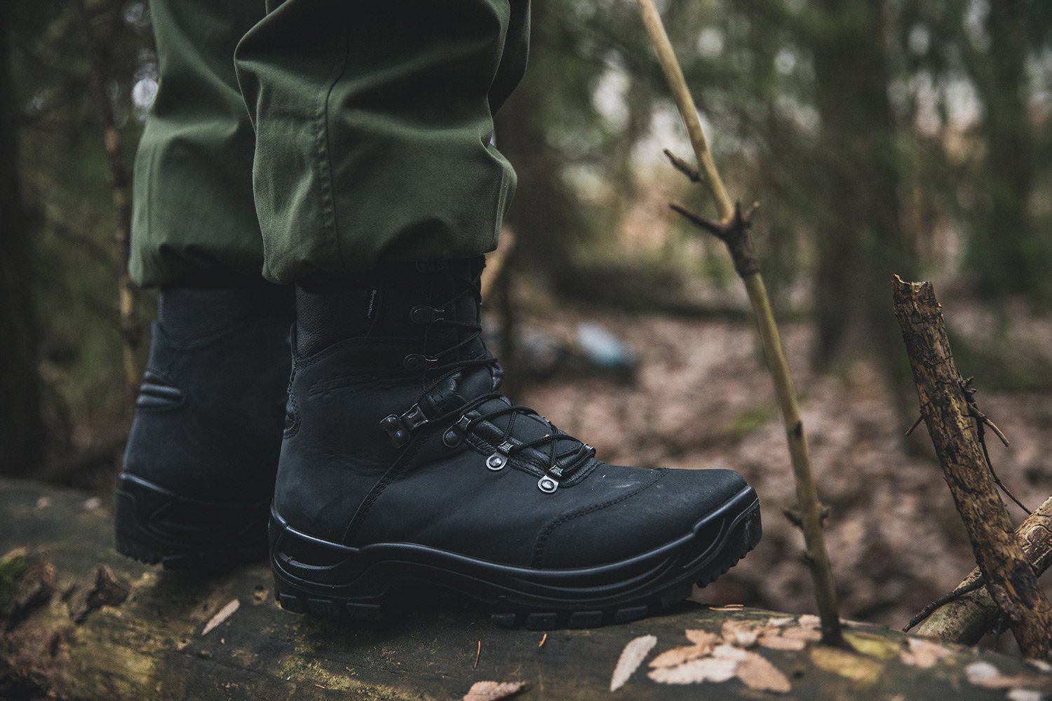 Black hiking boots in a forrest.