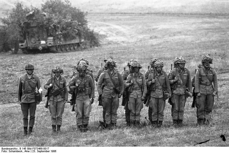 An archive photo from Bundesarchiv depicting soldiers standing in a row on a field. Foto:Schambeck, Arne, 23. September 1986.