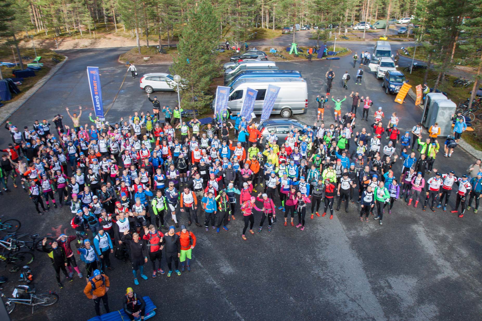 Ilmakuva osallistujajoukosta parkkialueella.
