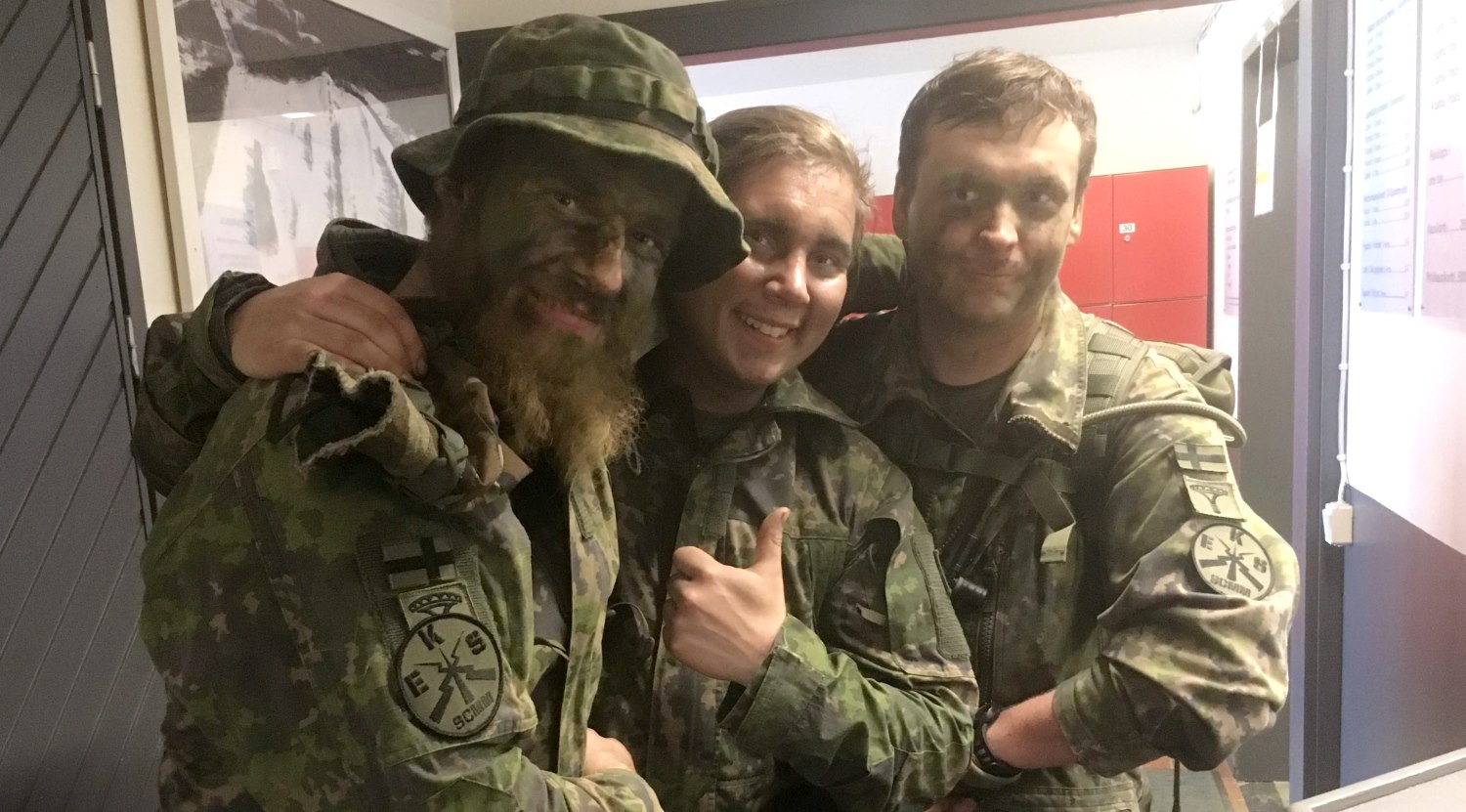 Three fighters posing for the camera with arms on eachother's shoulders.