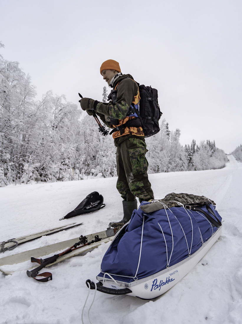 Toinen metsästäjä tien varressa suksien ja ahkion kanssa valmistautumassa.