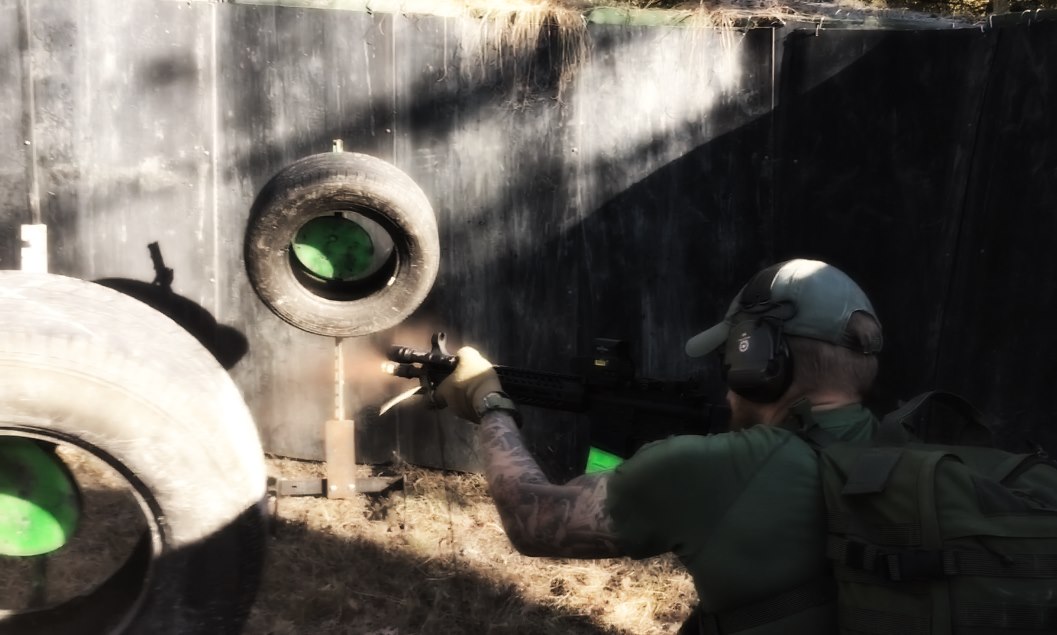 A man shooting at targets made of car tires with green circles inside them.