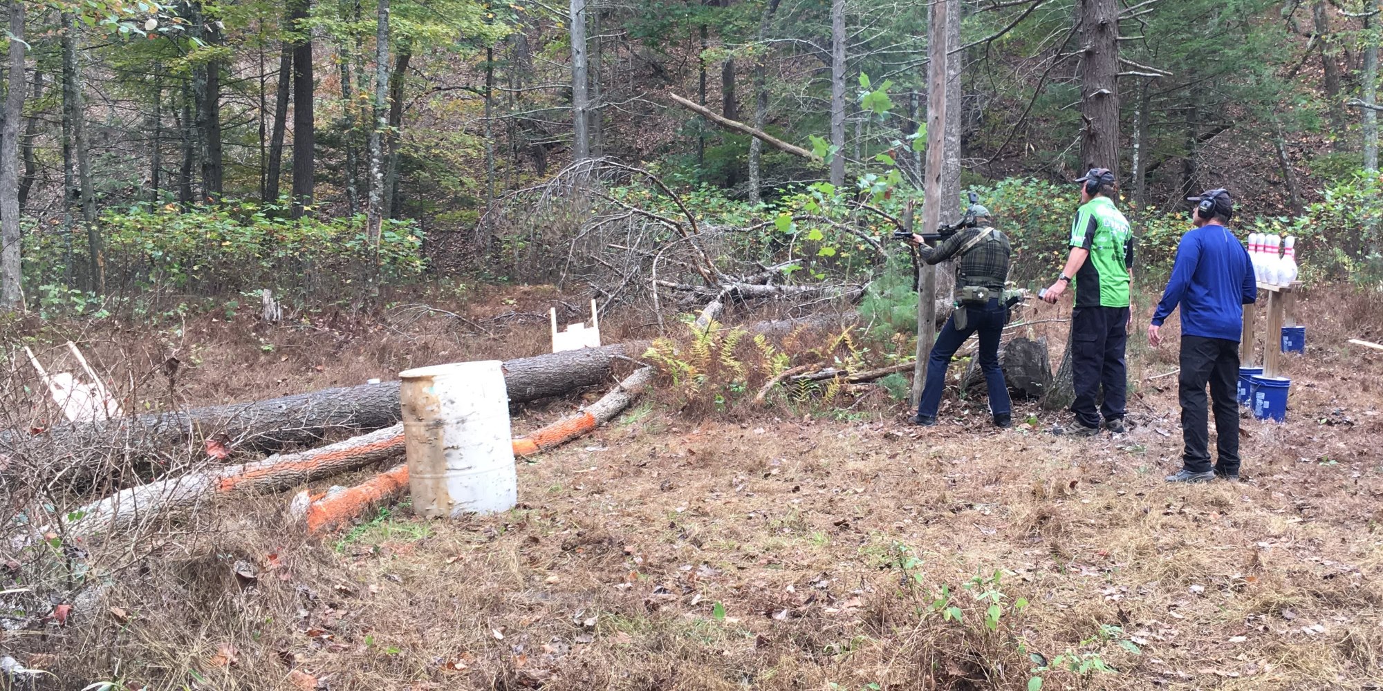 A shooting spot in the woods with the shooter and two officials.