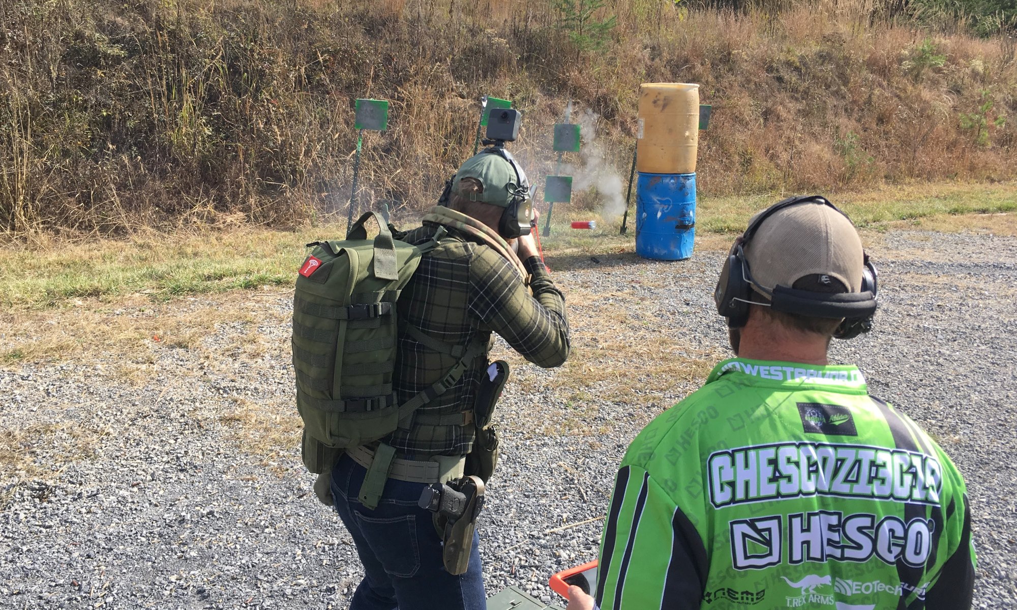 A man shooting at rectangular green targets standing up.