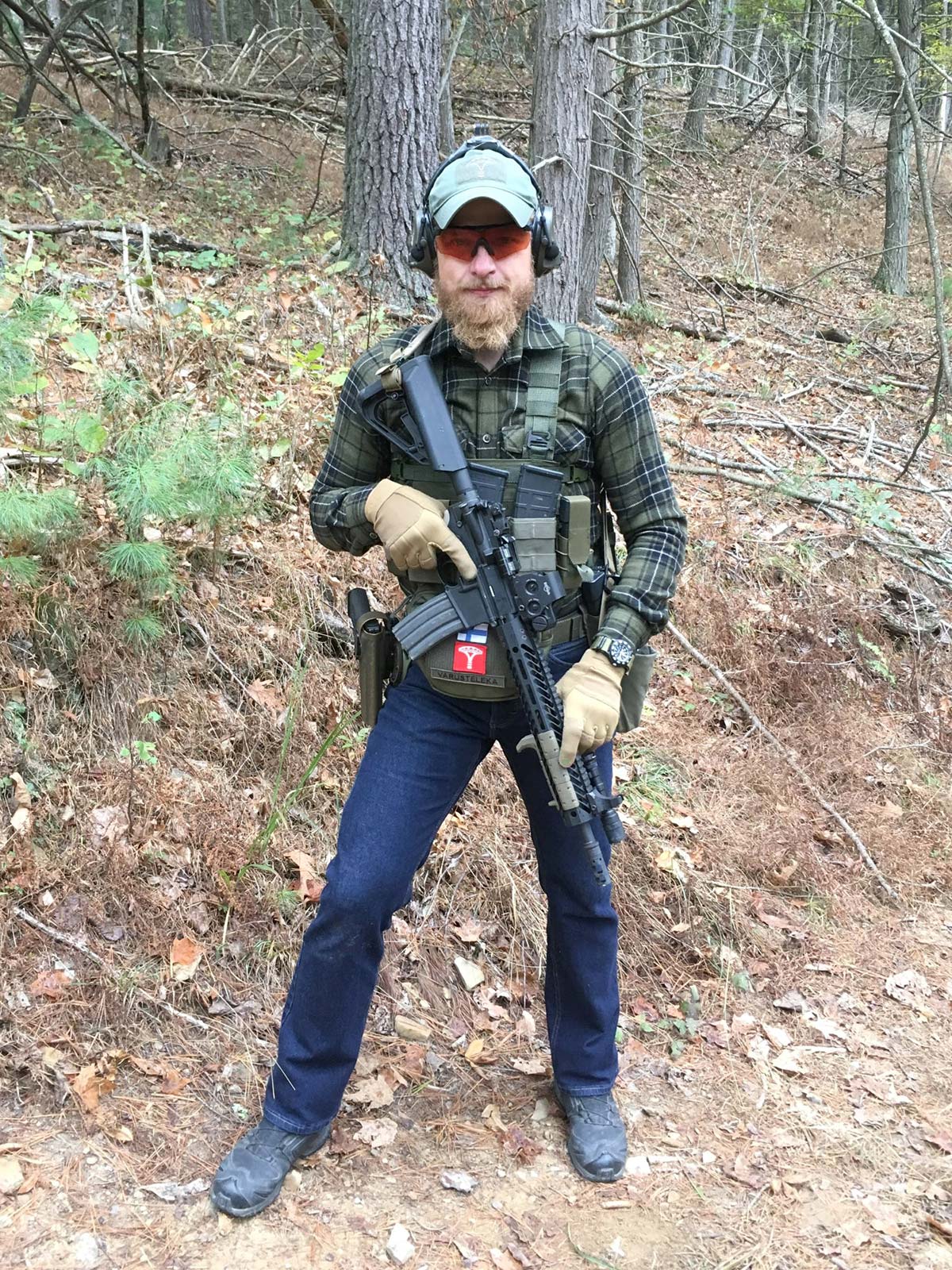 The shooter wearing a green plaid flannel shirt, blue jeans and a creen cap.