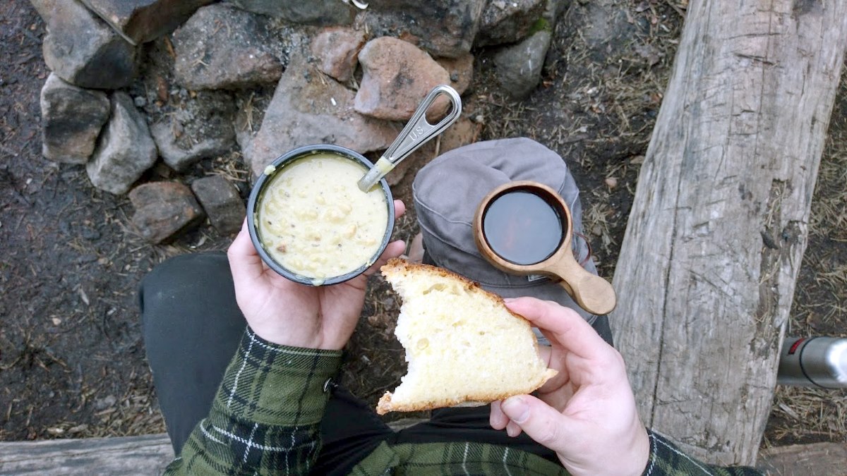 Nuotiolla paahdettua leipää ja hernekeittoa.