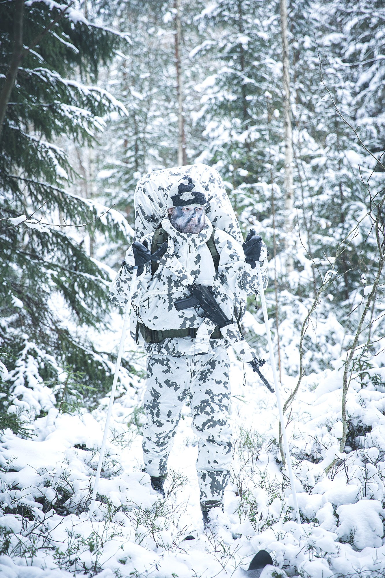 Fully snow camouflaged soldier skiing