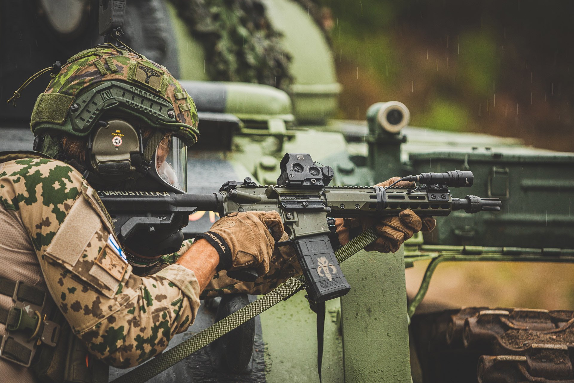 Man aiming with assault rifle in the rain