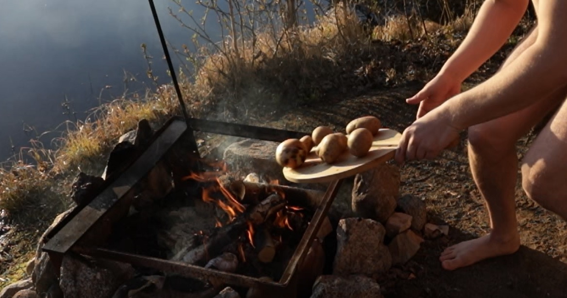 Potatoes being tossed from the chopping board to the fire.