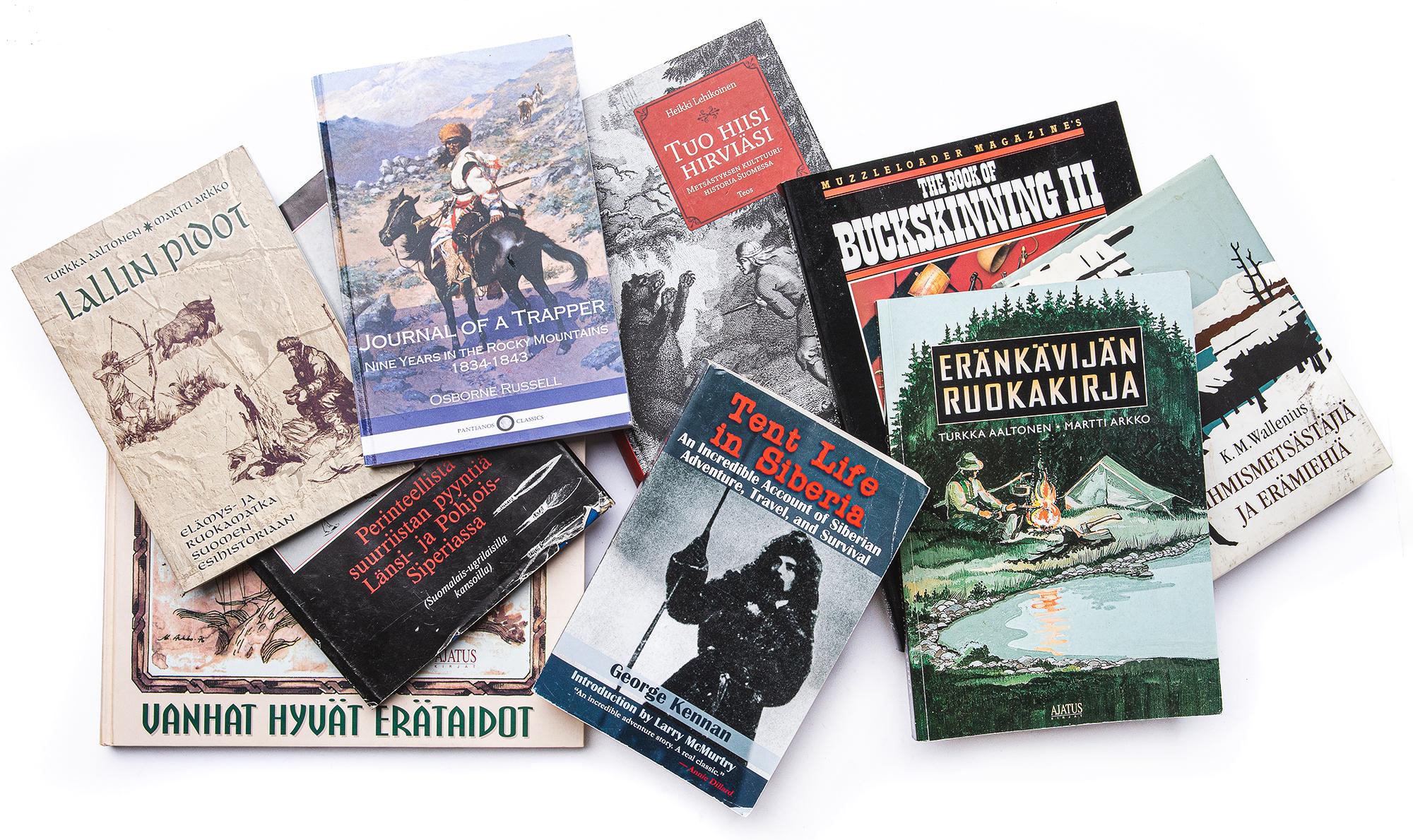 A pile of bushcraft books in English and Finnish
