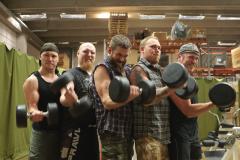 A spartan group of Varusteleka employees posing with kettle bells in the air.