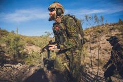 A man in tactical gear in the desert.