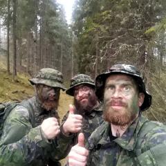 The three Varusteka sodiers participating on a Military March in camouflage in the woods.