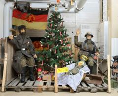 A Christmas diorama with dummies in mil gear set up on pallets.