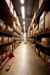 A more professional and organized looking warehouse with proper shelves and labeled card board boxes.