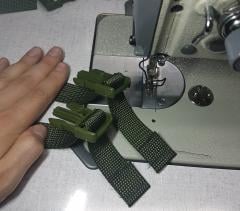 A sewing machine and two pieces of webbing with male buckles attached to them.