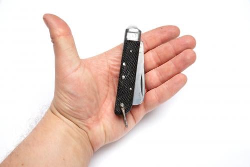 Italian pocket knife with can opener, surplus. The handle is textured black bakelite/plastic.
