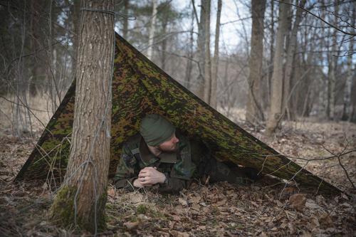 Särmä TST Rain poncho, M05 woodland camo. The poncho can be used to construct different types of emergency shelters.