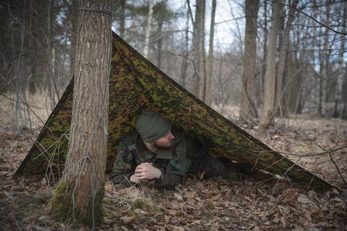 Särmä TST L6 Rain Poncho, M05 woodland camo. The poncho can be used to construct different types of emergency shelters.