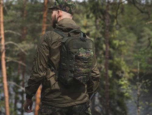 Särmä TST Rain poncho, M05 woodland camo. Rain poncho folded up into a neat little bundle and attached to the CP10 Mini Combat Pack using a lashing system made from shock cord.
