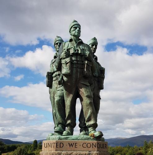 A statue of three soldiers standing together gazing forward.