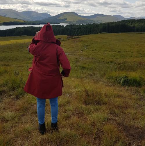 A person standing on a dfild in a red coat.