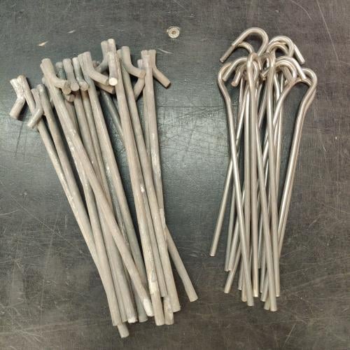 French F1 / F2 2-Person Tent, Surplus. The stakes may be either type: the stronger ones on the left or the lighter ones on the right, which weigh 25 grams (0.88 oz) a piece.