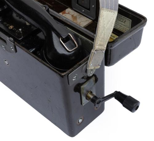 Finnish Field Telephone, Surplus. The crank can be found under the lid and it is screwed on the outside. It is used to activate and terminate the calls. The strap is not included!
